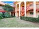 Exterior view of a two-story condo building with red stairs and balconies, framed by mature trees at 2804 N Powers Dr # 27, Orlando, FL 32818