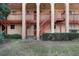 Exterior view of a two-story condo building with red accents, neutral paint, and multiple entrances at 2804 N Powers Dr # 27, Orlando, FL 32818