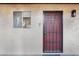Exterior view of a condo unit door with a secure metal gate and traditional-style exterior light at 2804 N Powers Dr # 27, Orlando, FL 32818