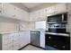 Well-lit kitchen with stainless steel appliances, bright white cabinets, and tiled backsplash at 2804 N Powers Dr # 27, Orlando, FL 32818