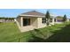 Exterior rear view featuring the home's backyard, patio, and sliding glass doors at 2854 Supermarine Rd, Tavares, FL 32778