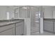Spacious bathroom featuring dual sinks, gray cabinets, and a glass shower at 2854 Supermarine Rd, Tavares, FL 32778