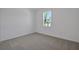 Neutral bedroom featuring carpet, white walls, and a bright window at 2854 Supermarine Rd, Tavares, FL 32778