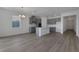 Open concept living room and kitchen with gray cabinets and hardwood floors at 2854 Supermarine Rd, Tavares, FL 32778