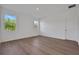 Bright bedroom featuring wood-look floors, two large windows, and neutral decor at 2932 Supermarine Rd, Tavares, FL 32778