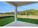 Covered patio offers an outdoor living space with views of the green backyard at 2932 Supermarine Rd, Tavares, FL 32778