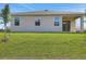 Exterior back view showing the three windows and a sliding glass door out to a covered patio at 2950 Supermarine Rd, Tavares, FL 32778