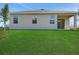 Exterior back view showing the three windows and a sliding glass door out to a covered patio at 2950 Supermarine Rd, Tavares, FL 32778