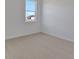 Bright bedroom featuring neutral carpeting and a window, creating a serene and comfortable retreat at 2950 Supermarine Rd, Tavares, FL 32778