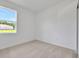 Serene bedroom with neutral carpeting and a window, offering a peaceful and inviting space at 2950 Supermarine Rd, Tavares, FL 32778