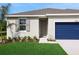 Inviting home with neatly landscaped front yard, neutral paint, and a striking blue garage door at 2950 Supermarine Rd, Tavares, FL 32778