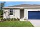 Inviting home with neatly landscaped front yard, neutral paint, and a striking blue garage door at 2950 Supermarine Rd, Tavares, FL 32778