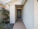 Close-up of the front door with security screen and decorative shrubbery on the side at 31234 Chevy Chase Dr, Sorrento, FL 32776