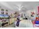 Bright bedroom features a ceiling fan, tv, dresser, and multiple decor items on the walls at 3215 Park Branch Ave, Clermont, FL 34711