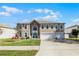 Beautiful two-story home with a three-car garage and a well-manicured lawn at 3215 Park Branch Ave, Clermont, FL 34711