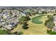An aerial shot of the homes, green lawns and a golf course at 3218 Woodridge Dr, The Villages, FL 32162