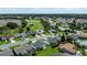 Wide aerial shot showcasing a golf course community with mature trees, well-maintained homes, and green lawns at 3218 Woodridge Dr, The Villages, FL 32162