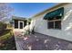 Relaxing back patio with brick pavers, green awnings, and comfortable seating for outdoor enjoyment at 3218 Woodridge Dr, The Villages, FL 32162
