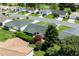 Overhead shot showing a home with a screened in porch and mature landscaping in a well-kept neighborhood at 3218 Woodridge Dr, The Villages, FL 32162