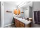 Bathroom with a wood vanity, grey walls, modern lighting, seashell decorations, and wood-look flooring at 3218 Woodridge Dr, The Villages, FL 32162