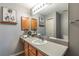 Well-lit bathroom with wood cabinets, a wide mirror, and stylish decor that enhances the space at 3218 Woodridge Dr, The Villages, FL 32162