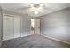 Neutral bedroom featuring a ceiling fan, a double closet, and grey carpeting with updated electrical outlets at 3218 Woodridge Dr, The Villages, FL 32162