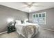 Neutral bedroom featuring a ceiling fan, a window with shutters, and a white bed and carpeting at 3218 Woodridge Dr, The Villages, FL 32162
