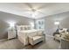 Serene bedroom with soft lighting, plush bedding, ceiling fan and comfortable seating at 3218 Woodridge Dr, The Villages, FL 32162