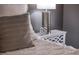 Close up of a bedroom featuring a nightstand and a decorative lamp at 3218 Woodridge Dr, The Villages, FL 32162