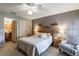 Comfortable bedroom features a ceiling fan, gray walls, and an ensuite bathroom with a wooden cabinet at 3218 Woodridge Dr, The Villages, FL 32162