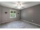 Neutral bedroom featuring a ceiling fan, a window, and grey carpeting with updated electrical outlets at 3218 Woodridge Dr, The Villages, FL 32162