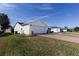 Exterior view features a brick driveway leading to an attached garage and a well-maintained lawn at 3218 Woodridge Dr, The Villages, FL 32162