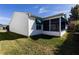 Exterior corner of the home featuring the vinyl siding, landscaping, and screened-in lanai at 3218 Woodridge Dr, The Villages, FL 32162