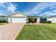Charming single story home with beautiful landscaping, brick driveway and a two car garage at 3218 Woodridge Dr, The Villages, FL 32162