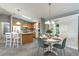 Open-concept kitchen and dining area with oak cabinets, island seating, and a cozy dining table set for four at 3218 Woodridge Dr, The Villages, FL 32162