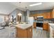 Bright kitchen features wooden cabinets, modern appliances, island, and seamless flow to the living area at 3218 Woodridge Dr, The Villages, FL 32162