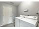 Clean laundry room with white appliances, gray walls, and a door leading to other areas at 3218 Woodridge Dr, The Villages, FL 32162