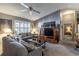Comfortable living room with gray couches, plantation shutters, and a decorative display cabinet for entertainment at 3218 Woodridge Dr, The Villages, FL 32162