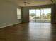 Living room with light gray walls, wood-look floors, ceiling fans, and sliding glass doors to a patio at 3300 Saratoga Dr, Tavares, FL 32778