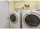 Laundry room with washer and dryer, white door and yellow walls at 3310 Osprey Hill St, Clermont, FL 34714