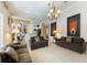 Spacious living room with tile flooring, neutral paint, and decorative chandelier is perfect for entertaining at 3310 Osprey Hill St, Clermont, FL 34714