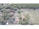 Aerial view of wooded property with a house, multiple outbuildings and pastures at 37807 Felkins Rd, Leesburg, FL 34788