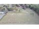 Scenic aerial shot of horse property with a house, red roof outbuildings, and perimeter fencing at 37807 Felkins Rd, Leesburg, FL 34788