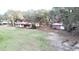 Expansive aerial view showcasing the property's main house, additional structures, green pastures, and mature trees at 37807 Felkins Rd, Leesburg, FL 34788