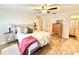 Cozy bedroom boasts a ceiling fan, wood look flooring and comfortable decor at 37807 Felkins Rd, Leesburg, FL 34788
