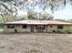 Charming single-story home featuring red shutters, a metal roof and cozy front porch at 37807 Felkins Rd, Leesburg, FL 34788