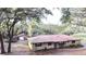 Charming exterior view of a single-story home featuring a red metal roof and separate garage at 37807 Felkins Rd, Leesburg, FL 34788