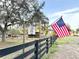 Farm entrance featuring a Full Circle Farm sign and an American flag along the black fence at 37807 Felkins Rd, Leesburg, FL 34788