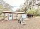 Detached garage with a light-colored exterior, complemented by equestrian facilities and surrounded by mature trees at 37807 Felkins Rd, Leesburg, FL 34788