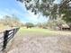 Expansive green field enclosed by a dark wooden fence creating a large space for various outdoor activities at 37807 Felkins Rd, Leesburg, FL 34788